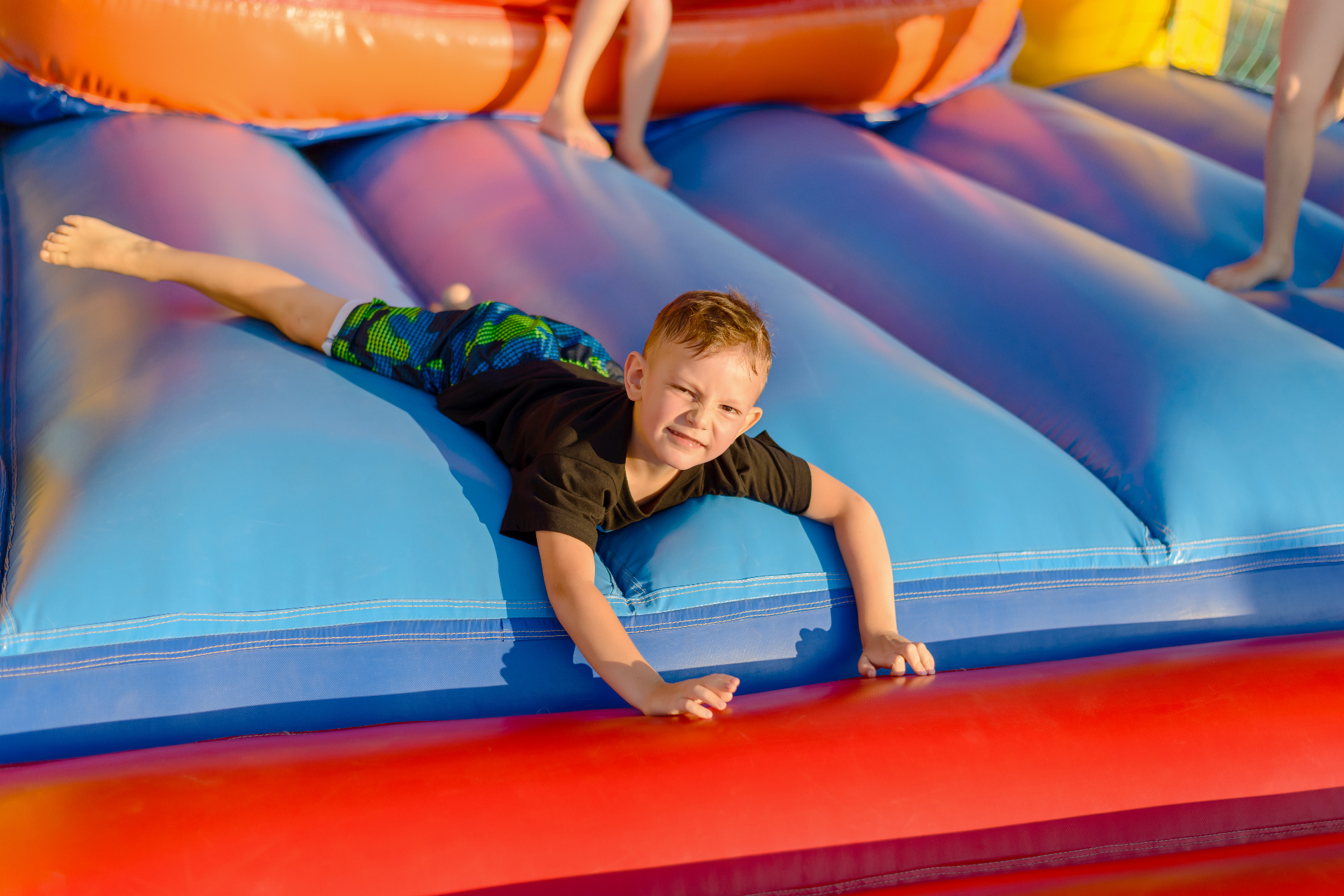 Kids sliding down an inflatable slide at a party